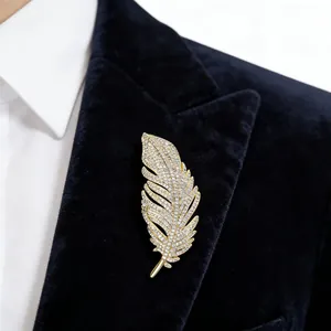 Exquisite gold feather brooch with full white diamonds on a dark navy blazer lapel