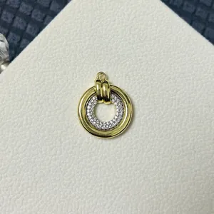 Close-up of circular double-loop pendant with gold finish and pavé cubic zirconia inlay