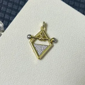 Macro shot of gold mermaid pendant with pave zircon insets and modern geometric frame