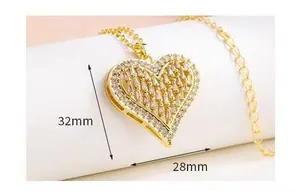 Dettaglio del ciondolo a cuore dorato con zirconi e dimensioni mostrate di 32x28mm