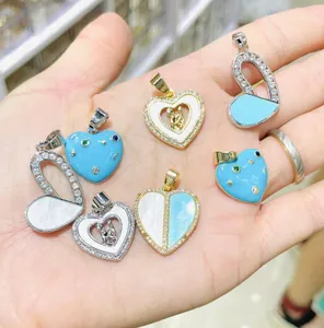 Macro detail of heart-shaped pendants with zircon, enamel, and mother of pearl inlay