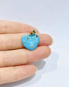Macro detail of heart pendant with blue enamel, star moon motifs and colorful cubic zirconia