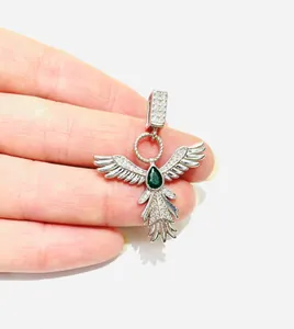 Dettaglio del ciondolo ad ala d'angelo in argento con una pietra di zircone verde a goccia