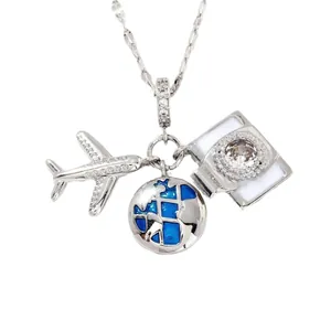Silver travel necklace with airplane pendant, blue globe and camera charms on white base