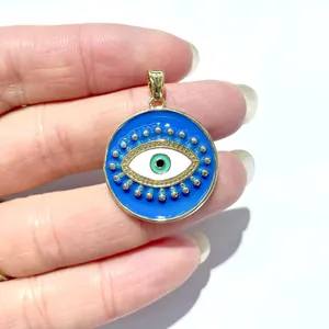 Makroaufnahme des Evil Eye Emaille-Anhängers in Gold, der die Größe und blaue Details zeigt
