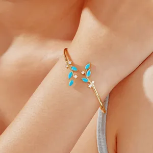 Elegant gold willow branch cuff bracelet with turquoise stones and zircons on wrist