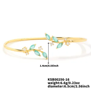 Detail view of gold branch cuff bracelet with marquise-cut turquoise and white zircon stones