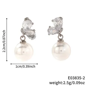 Detailed view of butterfly-shaped faux pearl earrings with cubic zirconia studs