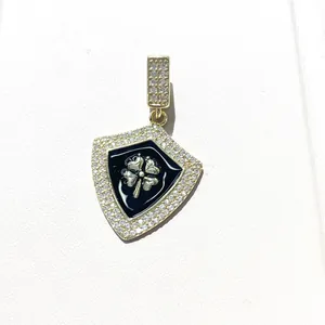 Detailed view of gold shield pendant with black enamel, lucky clover, and micro-pave zircons
