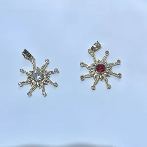 Elegant gold-plated sunflower pendants with white and red zircon stones in a top-down view