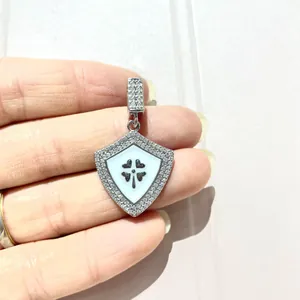 Detail of shield-shaped silver pendant with white enamel and micro-pave cubic zirconia