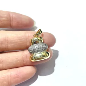 Three-layer two-tone pebble pendant with sparkling zircons held to show scale