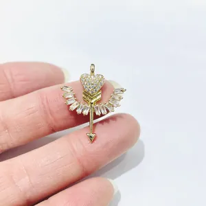 Macro detail of a gold-plated heart and arrow pendant with sparkling zircon wings