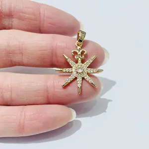 Elegant gold-plated star pendant with zircon stones held by hand to show medium size