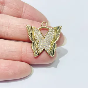 Macro detail of butterfly pendant with gold plating and pavé white zircon stones