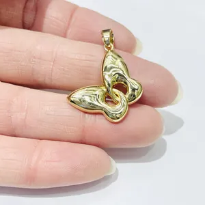 Detailed view of a small 18k gold-plated butterfly pendant with a polished finish