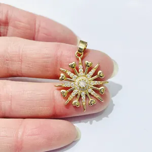 Detail of starburst pendant in gold finish with center zircon and heart-shaped elements