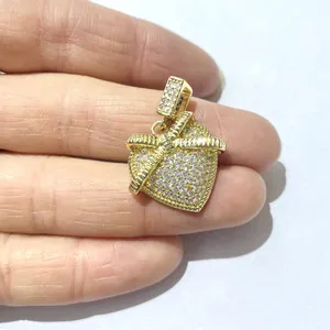 Ciondolo a cuore con zirconi micro-pavé in oro, tenuto in mano per mostrare le dimensioni