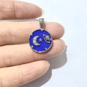 Close-up of star and moon celestial pendant with blue enamel inlay and tiny crystals