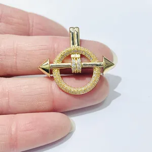 Macro view of gold plated arrow through crystal circle pendant with sparkling zircons