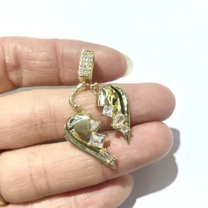 Dettaglio pendente cuore spezzato in oro con zirconi cubici incastonati a mano
