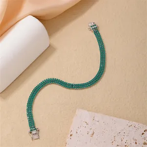 Detailed close-up of three-row green crystal tennis bracelet with silver clasp