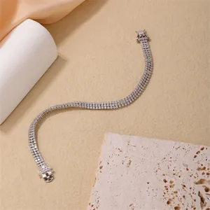 Detail of a triple-row sparkling tennis bracelet with silver metal and safety clasp