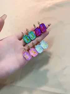 Close-up of four pairs of square colorful zircon earrings with gold leverback clasps