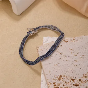 Detailed close-up of a three-row tennis bracelet with deep blue zircon in silver plating