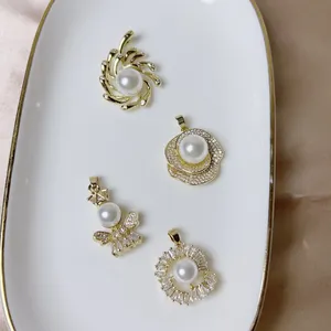 Elegant gold pearl pendants with zircon floral and bee designs on a satin background