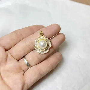 Luxurious gold floral pendant with white pearl center and shimmering zircon accents