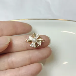 Detail eines drehbaren Kleeblatt-Anhängers mit Zirkon-Pflasterung und zentraler Perle
