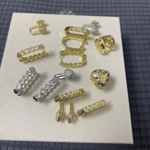 Flat lay of multiple zircon earrings in gold and silver finish on display board