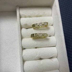 Macro shot of gold-plated geometric zircon earrings with hollow pattern in jewelry box