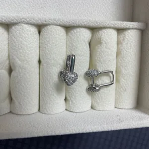 Macro shot of silver heart-shaped earrings with sparkling cubic zirconia on jewelry box