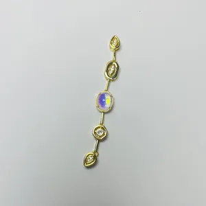 Detailed macro view of gold tassel necklace pendant with crystals and iridescent opal stone