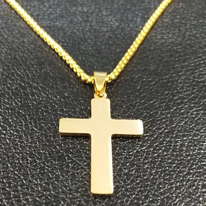 Macro view of polished gold stainless steel cross pendant on black leather texture