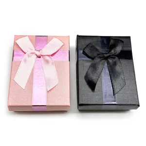 Detail of pink and black jewelry boxes with silk ribbons and textured paper finishes