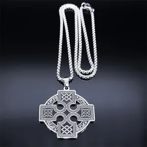 Detailed macro view of Celtic cross pendant with intricate knotwork on black surface
