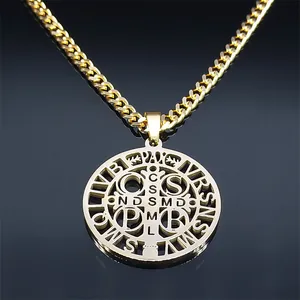 Macro shot of gold St. Benedict medal pendant with hollow religious engraving and chain