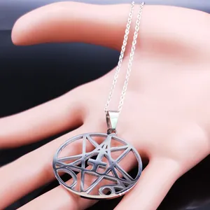 Macro detail of silver pentagram and inverted cross pendant on a metal link chain