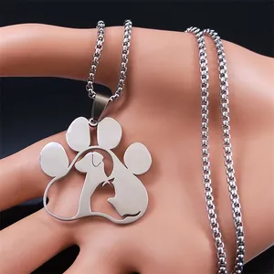 Detail of silver cat and dog paw print pendant on box chain worn on model hand