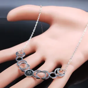 Macro shot of silver crescent moon phases and pentagram pendant on a thin metal chain
