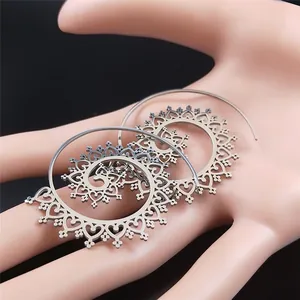 Makroaufnahme silberner Boho-Spiralfelgen mit Mandala-Hohlmustern auf der Hand