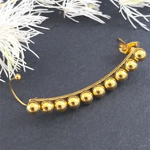 Golden multi-bead ear crawler earrings with nine polished spheres on a curved base