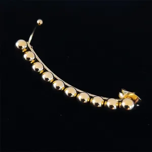 Detail of curved gold-tone ear crawler featuring ten polished metallic beads