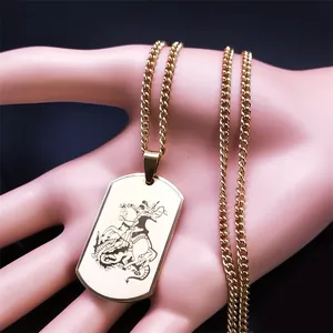 Detail of gold Archangel Saint Michael dog tag pendant with curb chain on a hand model