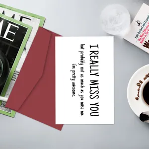 Flat lay of humorous greeting card and burgundy envelope with coffee and magazine lifestyle props