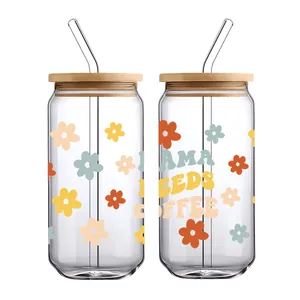 Detail van 16oz glazen beker met MAMA NEEDS COFFEE bloemenprint en bamboe deksel