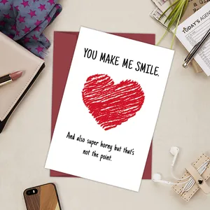 Close-up of funny romantic greeting card with red heart and envelope on aesthetic desk